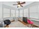 Cozy bedroom featuring a ceiling fan, hardwood floors, and lots of natural light from the multiple windows at 3887 Hickory Manor Dr, Suwanee, GA 30024