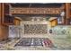 Close-up of the kitchen cooktop featuring a stone backsplash, granite countertops, and custom wooden cabinets at 3887 Hickory Manor Dr, Suwanee, GA 30024