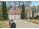 Elegant two-story brick residence with a manicured lawn and attached two-car garage in a serene setting at 3887 Hickory Manor Dr, Suwanee, GA 30024