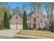 Attractive two-story brick home with a well-kept lawn and a convenient two-car garage at 3887 Hickory Manor Dr, Suwanee, GA 30024
