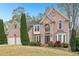 Beautiful two-story brick home showcasing manicured landscaping and an inviting front entrance at 3887 Hickory Manor Dr, Suwanee, GA 30024