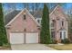 Lovely brick home featuring a two-car garage and mature landscaping, set in a peaceful neighborhood at 3887 Hickory Manor Dr, Suwanee, GA 30024