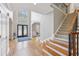 Welcoming foyer showcasing hardwood floors, a staircase, and abundant natural light from large windows at 3887 Hickory Manor Dr, Suwanee, GA 30024