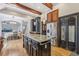 Open kitchen with central island, stainless steel fridge, dark cabinets, and hardwood flooring at 3887 Hickory Manor Dr, Suwanee, GA 30024
