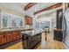 Open kitchen featuring dark cabinets, granite countertops, stainless steel appliances, hardwood floors, and a central island at 3887 Hickory Manor Dr, Suwanee, GA 30024