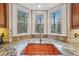 Beautiful kitchen sink with copper basin, granite countertops, bay windows, and natural light at 3887 Hickory Manor Dr, Suwanee, GA 30024