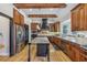 Charming kitchen featuring wooden cabinets, stainless steel appliances, granite countertops, and a black central island at 3887 Hickory Manor Dr, Suwanee, GA 30024