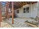 View of the covered patio with swing, brick-paved patio, stairs, and home exterior at 3887 Hickory Manor Dr, Suwanee, GA 30024