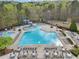 Aerial view of the community pool with a winding waterslide, multiple tables, and lounge chairs at 3887 Hickory Manor Dr, Suwanee, GA 30024