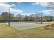 Pickleball courts and sand volleyball court offer recreation next to benches, benches, and a tree-lined green space at 3887 Hickory Manor Dr, Suwanee, GA 30024