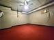 Spacious basement with red carpet and ceiling fan offers potential for versatile use at 1535 Wilkes Crest Dr, Dacula, GA 30019