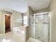 Bright bathroom showcasing a tub, shower with glass door, and neutral wall paint at 1535 Wilkes Crest Dr, Dacula, GA 30019
