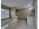 Well-lit bathroom featuring a tub, shower, vanity, and neutral color palette at 1535 Wilkes Crest Dr, Dacula, GA 30019