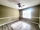 Sunlit bedroom showcasing a ceiling fan, neutral walls, and gleaming laminate floors at 1535 Wilkes Crest Dr, Dacula, GA 30019