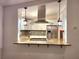 Renovated kitchen featuring white cabinets, a granite countertop pass-through, pendant lights, and stainless steel appliances at 2089 Lenox Rd, Atlanta, GA 30324