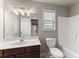 Bathroom boasts a wood vanity, a white countertop, and a large framed mirror at 2172 Misty Brook Ct, Buford, GA 30519