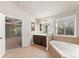 Bright bathroom showcasing a tub, vanity, and a doorway with views into the main bedroom at 2172 Misty Brook Ct, Buford, GA 30519