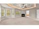 Primary bedroom featuring multiple windows, fireplace, and tray ceiling at 2172 Misty Brook Ct, Buford, GA 30519