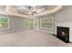 Primary bedroom featuring multiple windows, fireplace, and tray ceiling at 2172 Misty Brook Ct, Buford, GA 30519