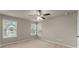 Neutral bedroom with carpet, ceiling fan, and two windows at 2172 Misty Brook Ct, Buford, GA 30519