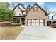 Charming two-story brick home with a well-manicured lawn and inviting two-car garage at 2172 Misty Brook Ct, Buford, GA 30519