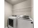 This laundry area has a washer and dryer with a wire shelf above at 2172 Misty Brook Ct, Buford, GA 30519