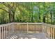 Wooden back deck that overlooks a spacious backyard with a wooded border and privacy fence at 5570 Downs Way, Lithonia, GA 30058
