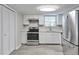 Modern kitchen with stainless steel appliances, white cabinets, and durable flooring at 5570 Downs Way, Lithonia, GA 30058