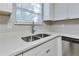 Close-up of a stainless steel kitchen sink with white countertops and cabinets at 5570 Downs Way, Lithonia, GA 30058