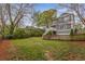 Spacious backyard featuring a grassy lawn, wooden fence, and a view of the home's exterior with a second-story deck at 791 Woodland Se Ave, Atlanta, GA 30316
