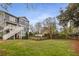 A sprawling backyard features a green lawn, wooden fence, and view of the home with an upper deck at 791 Woodland Se Ave, Atlanta, GA 30316