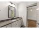 Bathroom with white vanity, dark countertop, and a view into the next room through the open doorway at 791 Woodland Se Ave, Atlanta, GA 30316
