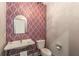 Charming powder room with patterned wallpaper, a decorative mirror, and pedestal sink at 791 Woodland Se Ave, Atlanta, GA 30316