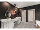 Luxurious bathroom with double vanity, modern lighting fixtures, and striking patterned tile floor with black accent wall at 791 Woodland Se Ave, Atlanta, GA 30316