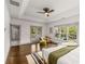 Bright bedroom with hardwood floors, tray ceiling, ceiling fan, and access to the balcony, plus large windows at 791 Woodland Se Ave, Atlanta, GA 30316