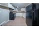 An older kitchen features a black refrigerator, stove, white cabinets, and tiled floors, offering a functional space at 1753 Thomas Ter, Decatur, GA 30032