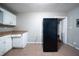 The kitchen features a black fridge, white cabinets, and tile floor, with a doorway leading to the rest of the house at 1753 Thomas Ter, Decatur, GA 30032