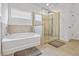 A bathroom with a walk-in shower with glass door and a soaking tub at 312 Amble Side, Mcdonough, GA 30252