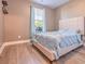 Cozy bedroom featuring wood-look floors, a large window, and a bed with a blue comforter at 312 Amble Side, Mcdonough, GA 30252