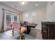 A naturally lit dining area with gray wood floors and gold-accented, pink chairs at 312 Amble Side, Mcdonough, GA 30252