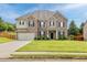 Inviting two-story home with a green lawn, a brick facade, and a spacious two-car garage at 312 Amble Side, Mcdonough, GA 30252