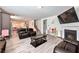 Open-concept living room with wood-look flooring, fireplace, and sleek furniture at 312 Amble Side, Mcdonough, GA 30252