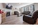 Bright living room with a fireplace and dark brown leather furniture set on wood-look floors at 312 Amble Side, Mcdonough, GA 30252