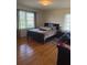 Cozy bedroom featuring a large bed, bright windows, and warm wood flooring at 3674 Canton Rd, Marietta, GA 30066