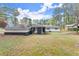 Expansive backyard featuring a patio connecting to a white home trimmed in black with ample outdoor space at 1990 Venetian Sw Dr, Atlanta, GA 30311