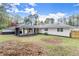 Spacious backyard features a covered patio and a white home with black accents and a fenced perimeter at 1990 Venetian Sw Dr, Atlanta, GA 30311