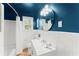 Intimate bathroom with dark blue walls and an elegant vanity with white counter and cabinets at 1990 Venetian Sw Dr, Atlanta, GA 30311
