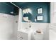 Charming bathroom with blue walls, white trim, and round mirror over the vanity at 1990 Venetian Sw Dr, Atlanta, GA 30311