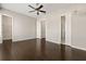 Spacious bedroom featuring dark wood floors, ceiling fan, and access to bathroom and closet at 6812 Cadence Blvd, Atlanta, GA 30328
