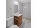Bathroom with a wooden vanity, sink, toilet, shower with white tiled walls and mosaic tile floor at 131 Brownlee Rd, Atlanta, GA 30331